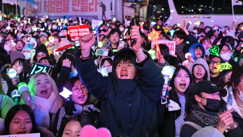 Protesters calling for the ouster of South Korea President Yoon Suk Yeol react after the result of the second martial law impeachment vote outside the National Assembly in Seoul on December 14, 2024. South Korean lawmakers on December 14 voted to remove President Yoon Suk Yeol from office for his failed attempt to impose martial law last week. 