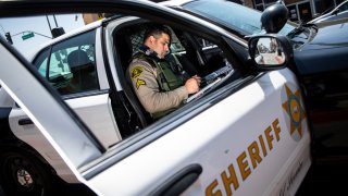 LOS ANGELES, CA – April 16: Los Angeles County Sheriffs deputy Manan Butt prepares to issue a ticket and release a man he detained in the back seat of his cruiser, during a traffic stop on Whittier Boulevard, in the heart of East Los Angeles, Friday, April 16, 2021. (Jay L. Clendenin / Los Angeles Times via Getty Images)