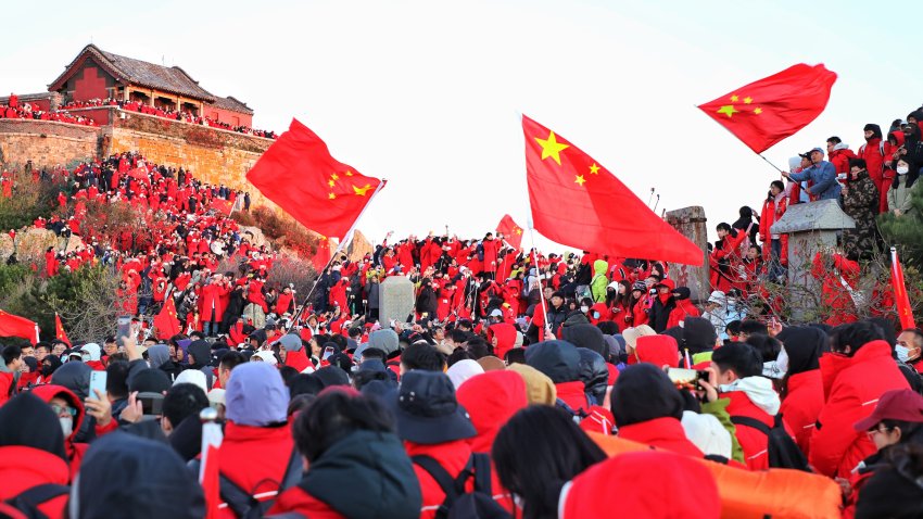 File. Tourists holding Chinese national flags visit Mount Tai during the National Day holiday on October 2, 2024 in Taian, Shandong Province of China.