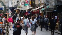 Pedestrians wear protective face masks while passing stores and cafes on Rue Montorgueil in Paris, France, on Wednesday, Aug. 26, 2020.