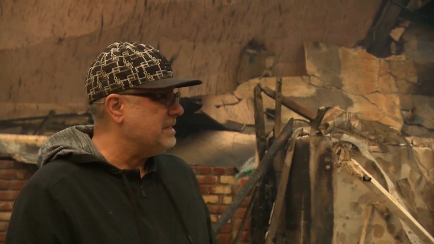 A man in Malibu in front of his burned home