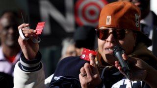 A community advocate cuts a Target credit card during a news conference outside Target Corporation's headquarters