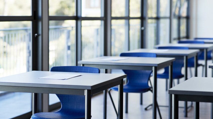 Papers on desks by window in classroom at university