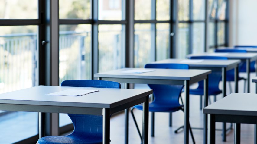 Papers on desks by window in classroom at university