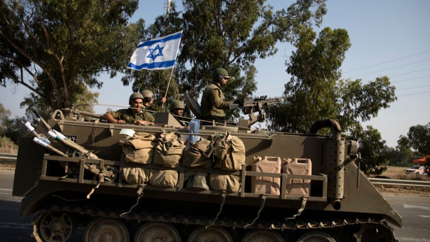 Israeli soldiers in an armoured personnel carrier head towards the southern border with the Gaza Strip on October 8, 2023 in Sderot, Israel.