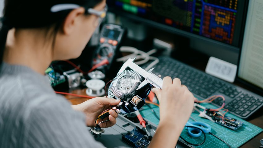 Engineer measures size of circuit board in this generic image.