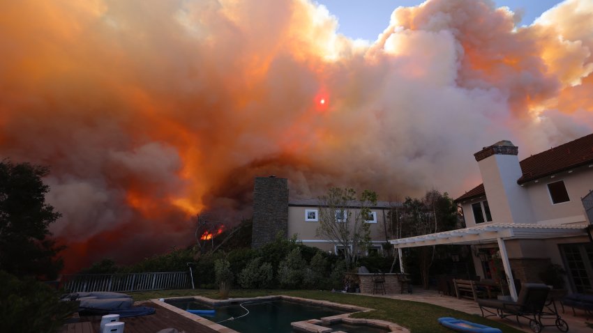 A brush fire burns near homes in Pacific Palisades, California on January 7, 2025. A fast-moving brushfire in a Los Angeles suburb burned buildings and sparked evacuations Tuesday as “life threatening” winds whipped the region. More than 200 acres (80 hectares) was burning in Pacific Palisades, a upscale spot with multi-million dollar homes in the Santa Monica Mountains, shuttering a key highway and blanketing the area with thick smoke. (Photo by David Swanson / AFP) (Photo by DAVID SWANSON/AFP via Getty Images)