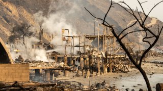 Fernwood, CA – January 09: A Kern County firefighter douses hot spots from the remains of a beachfront along the pacific coast in Malibu on Thursday, January 9, 2025.  (Photo by David Crane/MediaNews Group/Los Angeles Daily News via Getty Images)