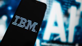 The IBM logo is displayed on a smartphone in Poland.