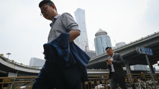 Pedestrians walk along a street in Beijing’s Central Business District on July 9, 2024.