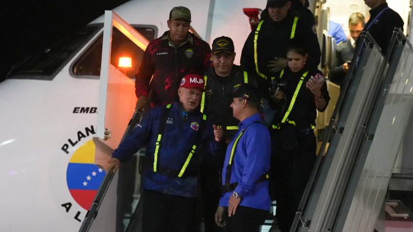 Venezuelan Interior Minister Diosdado Cabello, front left, walks off a plane that transported migrants deported from the United States at Simon Bolivar International Airport in Maiquetia, Venezuela, Monday, Feb. 10, 2025.