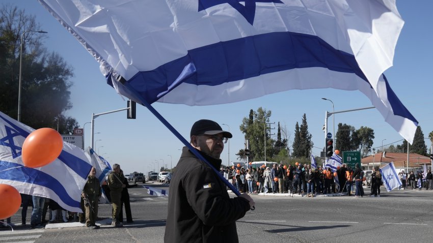 Israelis gather on the side of a road where the funeral convoy carrying the coffins of slain hostages Shiri Bibas and her two children, Ariel and Kfir, will pass by near Kibbutz Yad Mordechai, Israel, Wednesday, Feb. 26, 2025.