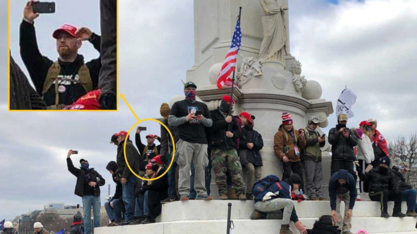 Edward Kelley at the Peace Monument across from the U.S. Capitol Building using a cell phone and wearing a red MAGA on Jan. 6, 2021.