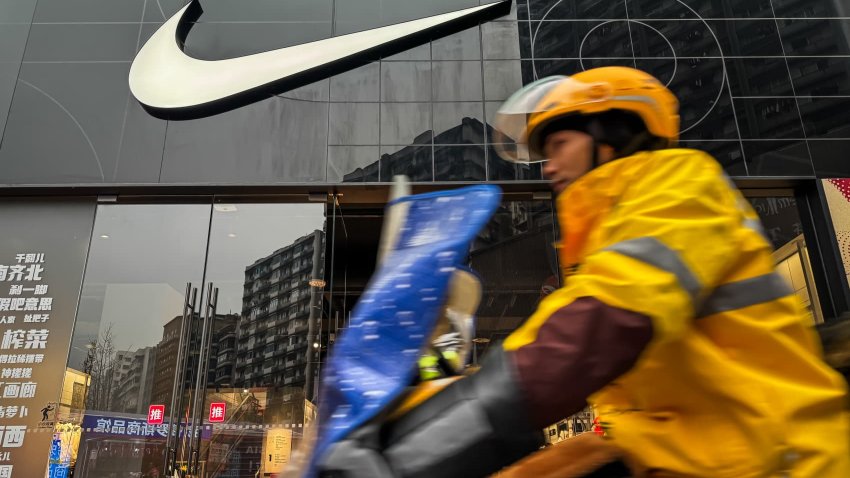 A delivery rider passes by a Nike retail store on Dec. 29, 2024, in Chongqing, China.