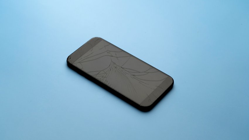 broken phone on the blue table background