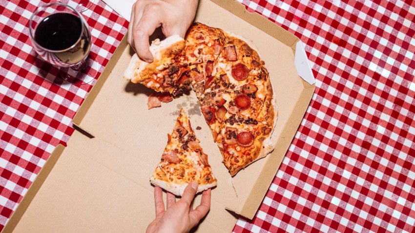 Top view of friends eating pepperoni pizza and drinking wine