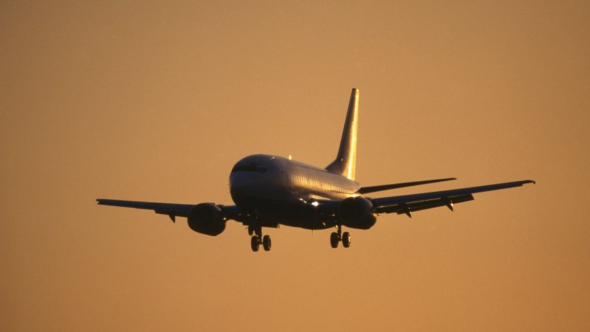 File. generic Boeing 737-300 on final-approach with flaps deployed and sun glinting off the fuselage and tail.