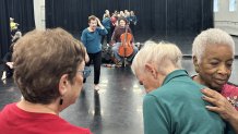 Arts for the Aging Quicksilver dancers embrace during a group rehearsal as artistic director Nancy Havlik prompts movement and musical director Adam Gonzalez provides live cello accompaniment.