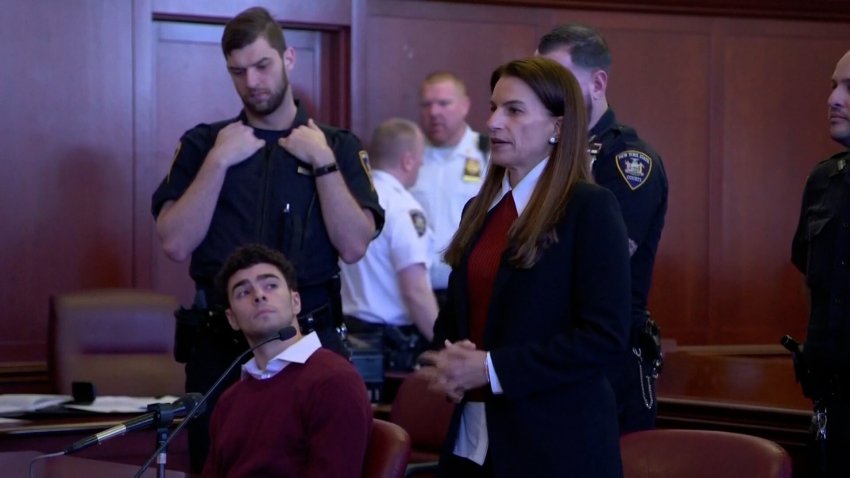 Luigi Mangione in a courtroom behind an attorney.