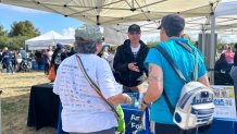 Nghia Huynh (center) volunteers for the American Foundation for Suicide Prevention at the NAMI Walks and Mental Wellness Expo, April 26, 2025.