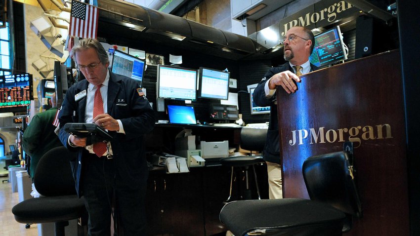 Traders work at the JPMorgan Chase & Co. booth on the floor of the New York Stock Exchange.