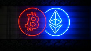 People walk past a neon sign advertising a Bitcoin and Ethereum crypto currency exchange in Warsaw, Poland on 19 May, 2024.