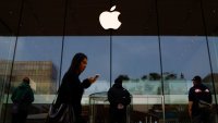 People stand in front of an Apple store in Beijing, China, on April 9, 2025.