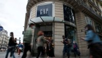 People walk past the entrance of a Gap store in Paris, France, July 1, 2021.