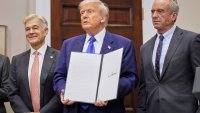 President Donald Trump, with Dr. Mehmet Oz, Administrator of the Centers for Medicare & Medicaid Services, left, and Health and Human Services Secretary Robert F. Kennedy Jr., right, holds an executive order related to drug prices, in the Roosevelt Room of the White House in Washington, Monday, May 12, 2025, in Washington.