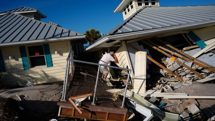A property owner who preferred not to give his name peers into the remains of the second floor unit where he lived with his wife while renting out the other units, on Manasota Key, in Englewood, Fla.,