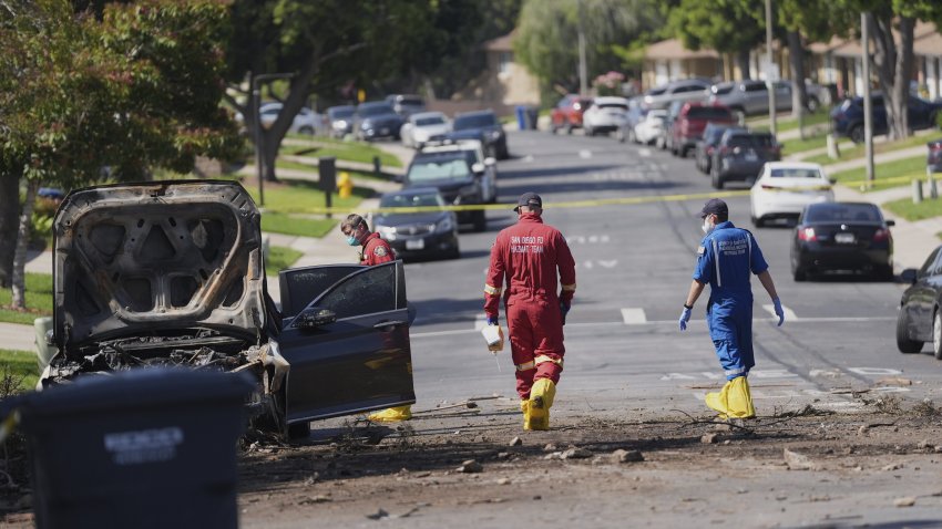Authorities work the scene where a small plane crashed into a San Diego neighborhood, setting several homes on fire and forcing evacuations along several blocks early Thursday, May 22, 2025. (AP Photo/Gregory Bull)