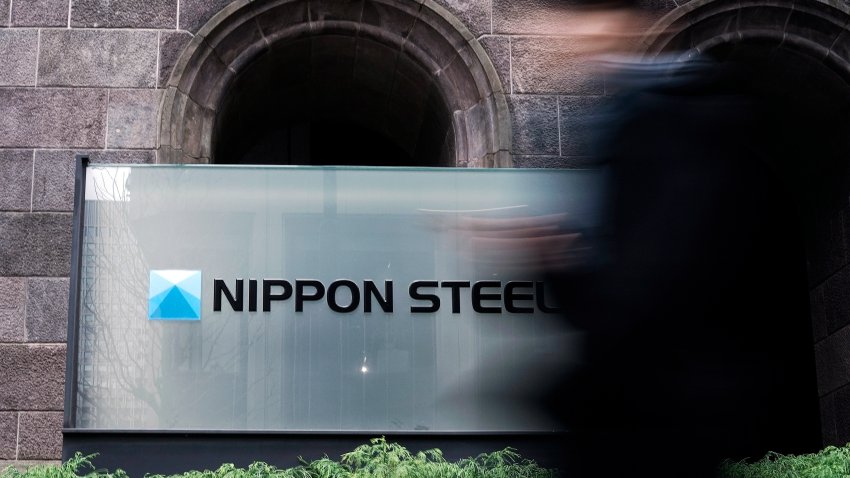FILE - A person walks past a Nippon Steel Corporation sign at the company headquarters on Jan. 7, 2025, in Tokyo.