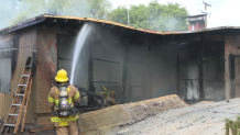 A firefighter douses the Lane family's home in Dulzura to keep flames from re-igniting.