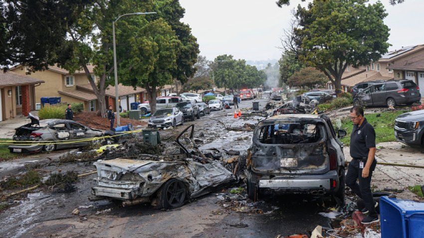 Investigators look through the site where a small plane crashed on a San Diego, California, residential street on May 22, 2025. The Federal Aviation Authority said a Cessna 550 crashed at around 3:45 am local time. The neighborhood is close to the Montgomery-Gibbs Executive Airport. The crash left a "gigantic debris field" and damaged several homes and parked cars.