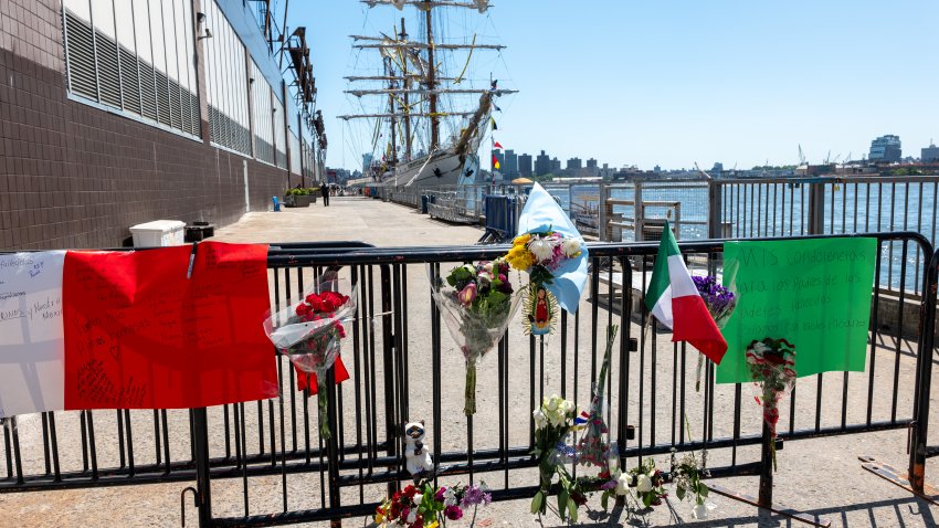 NEW YORK, NEW YORK – MAY 19: Flowers and flags are placed on a gate by a damaged Mexican Navy sailing ship, the Cuauhtémoc, that crashed into the Brooklyn Bridge over the weekend in lower Manhattan on May 19, 2025 in New York City. The collision, which snapped all three of the masts on the ship as it collided with the landmark bridge, killed at least two crew members and injured 19 others. (Photo by Spencer Platt/Getty Images)