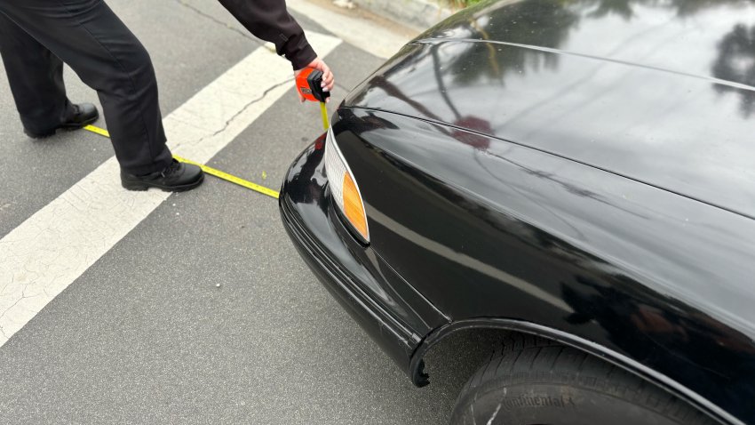 A police officer measures the distance between a car and the intersection in San Diego, May 2, 2025.