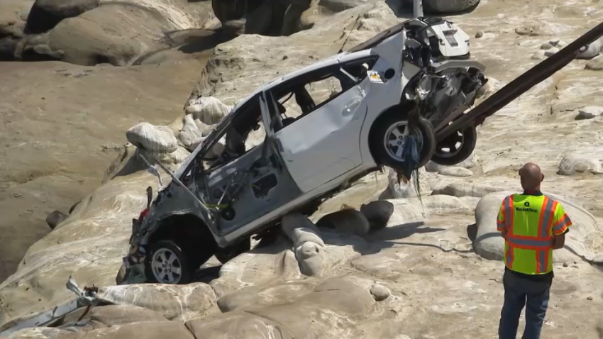 A tow crew pulls the battered white Toyota from the sea in La Jolla on April 30, 2025.