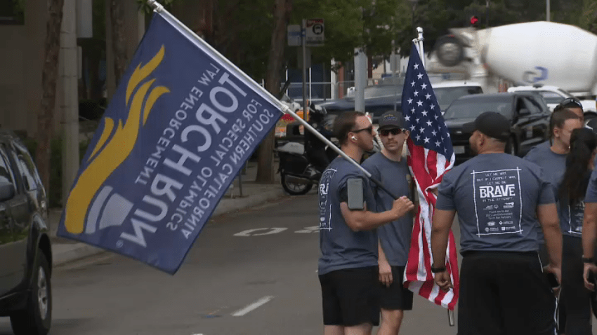 A law enforcement officer carries the flag for the annual Torch Run in support of the Special Olympics on May 27, 2025.