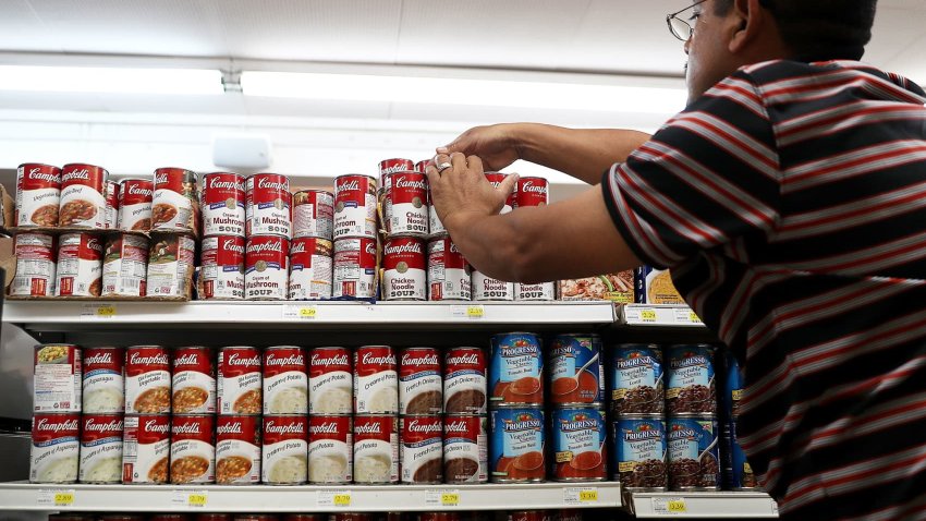 A worker arranges cans of Campbell’s soup on a supermarket shelf in San Rafael, California.