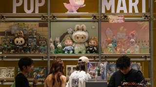 Customers browse a POP MART display filled with Labubu characters and collectible figures from The Monsters series on June 16, 2025 in Chongqing, China.
