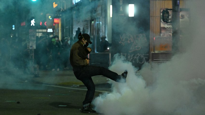 A protester kicks a canister during a protest in response to federal immigration operations in the Little Tokyo neighborhood of downtown Los Angeles, on June 9, 2025. President Donald Trump's administration said on June 9 that it was sending 700 US Marines and thousands more National Guard troops to Los Angeles, sparking a furious response from California's governor over the "deranged" deployment. Protests in Los Angeles, home to a large Latino population, broke out on June 6, triggered by immigration raids that resulted in dozens of arrests of what authorities say are illegal migrants and gang members. (Photo by RONALDO SCHEMIDT / AFP) (Photo by RONALDO SCHEMIDT/AFP via Getty Images)