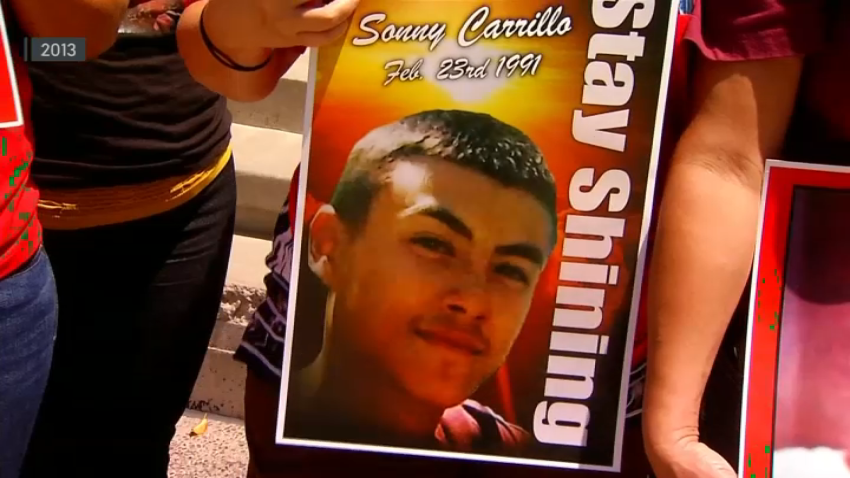 A person holds a photo of Sonny Carrillo that reads, “Stay shining,” in 2013.