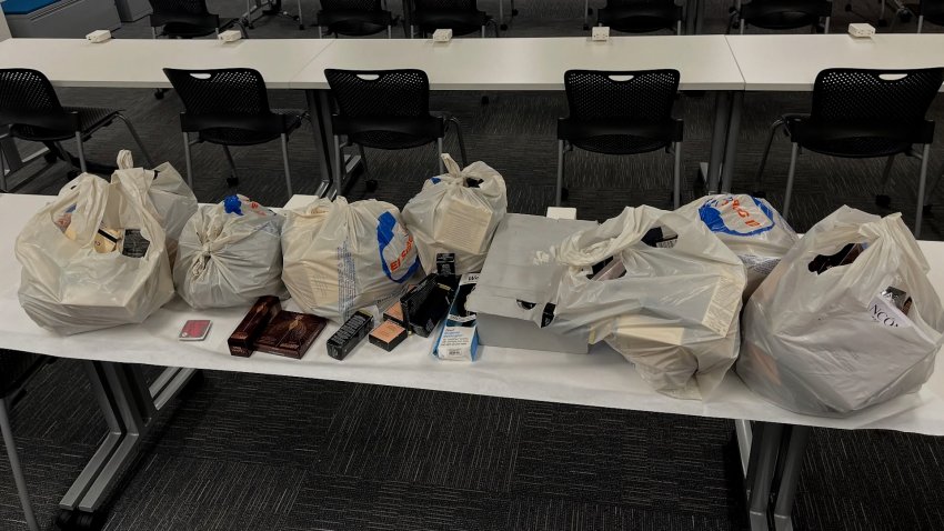 Shopping bags filled with stolen items on a table.