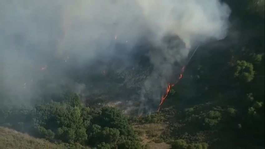 A fire burns in Tecolote Canyon on June 24, 2025.