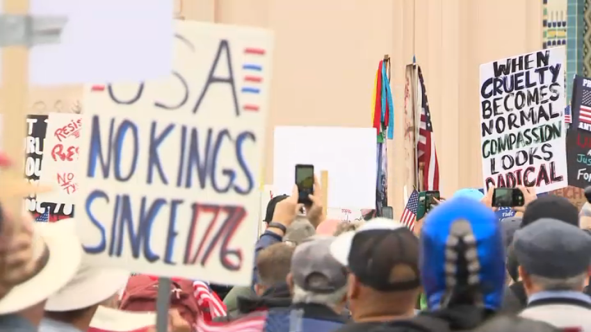 Signs are shown as demonstrators gathered at the San Diego County Administration building during a ‘No Kings’ protest, June 14, 2025.
