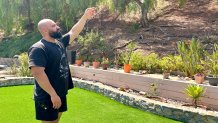 Fadi Alkass stands in his backyard, Sunday, pointing to the hillside  spared by a brush fire last month, Jamacha, August 3, 2025.