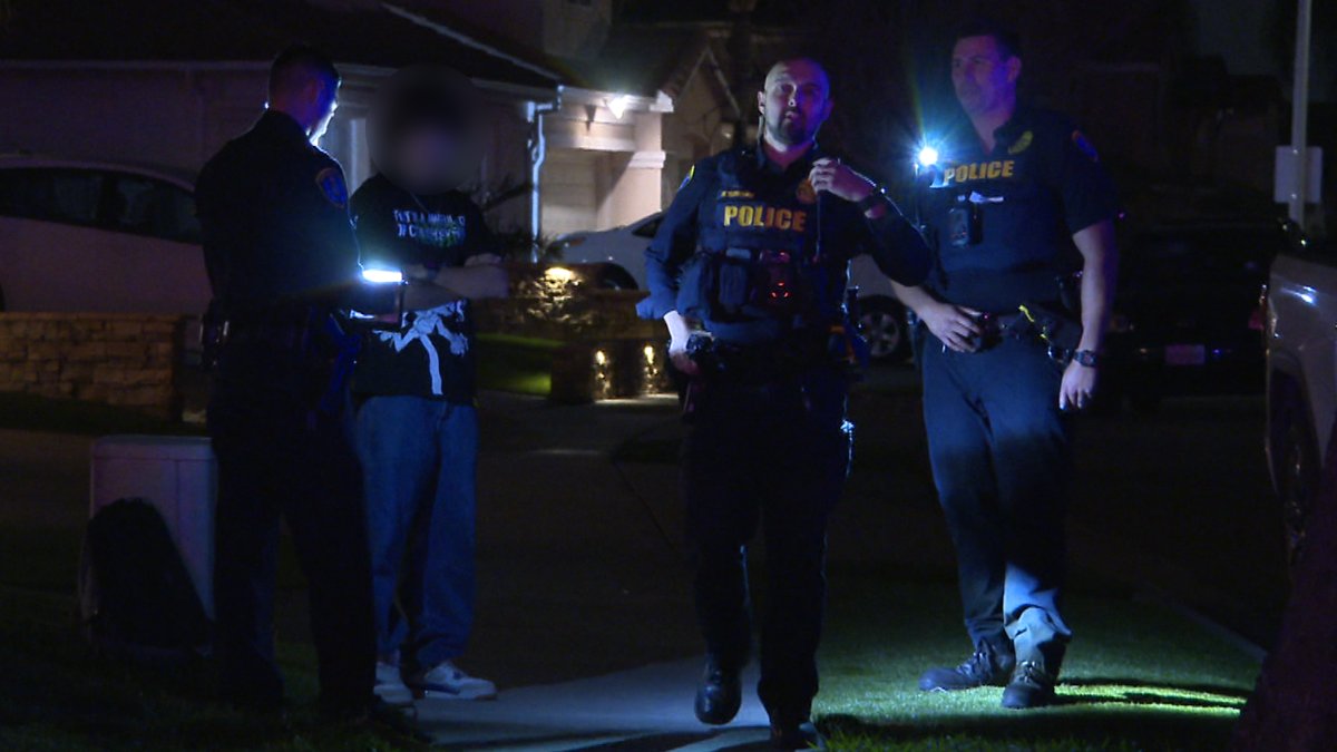 San Diego police officers talk to a young-looking individual seen leaving an illegal party in January in Otay Mesa.