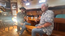 Don Johnson (left) sits in the ship's dining space below desk with sailing instructor, John Ziolkowski (right), April 4, 2026.