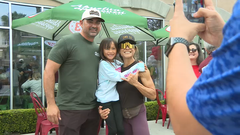 Former MLB star Adrian Gonzalez takes a photo with fans outside his new taco shop, Tres Dos Tres.