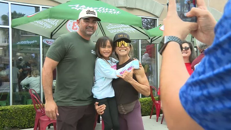 Former MLB star Adrian Gonzalez takes a photo with fans outside his new taco shop, Tres Dos Tres.
